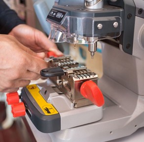 locksmith cutting keys with his cutting machine