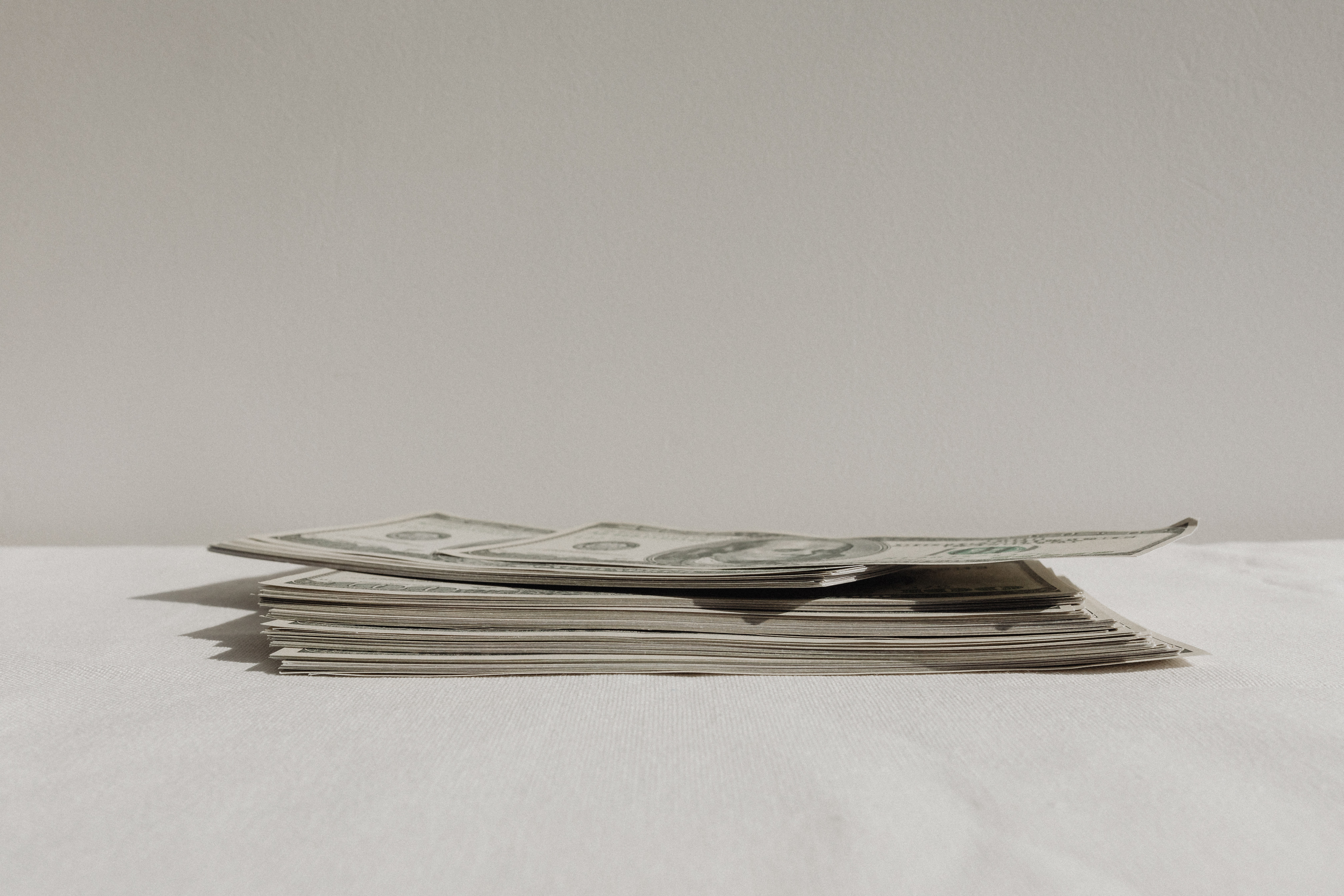 A winding road cuts through rocky terrain, surrounded by patches of green grass and illuminated by sunlight.