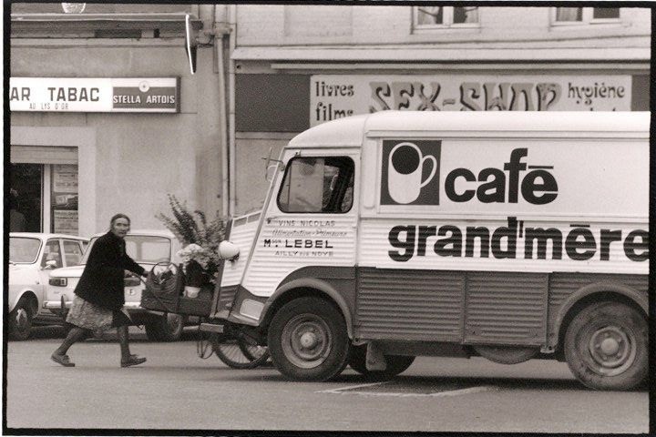 woman in brown long-sleeved top standing beside wall