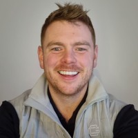 a man with a goatee smiles at the camera