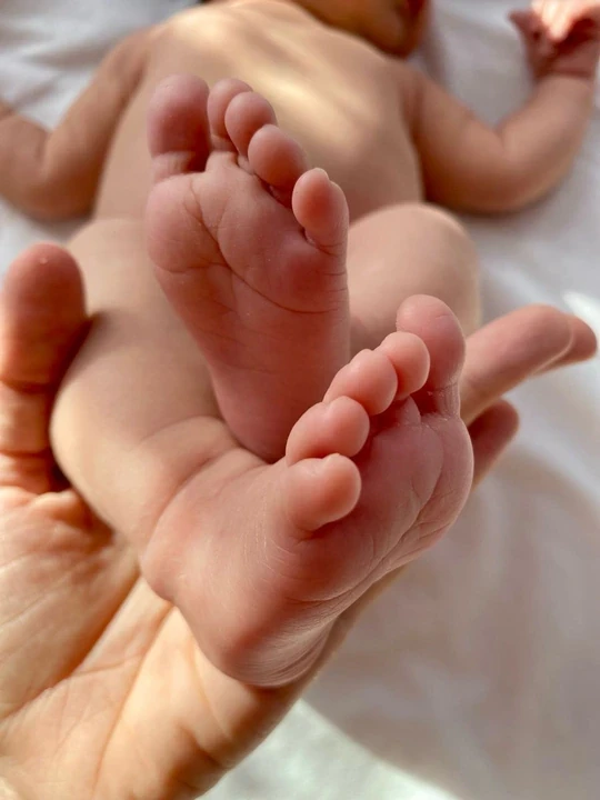 Close-up of baby soles resting in an adult hand