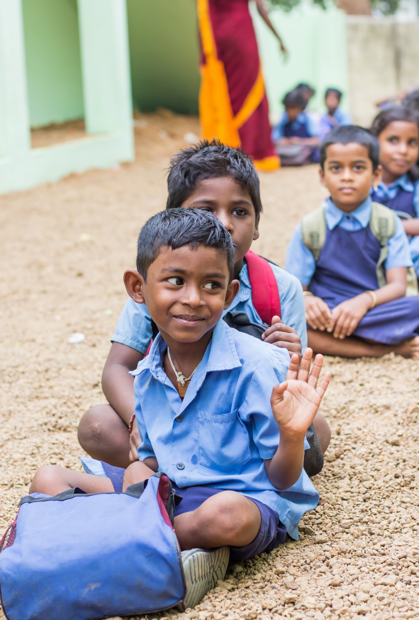 Students sitting in a row in Sevalaya school assembly ground where Sunmeister Energy has installed solar power plant