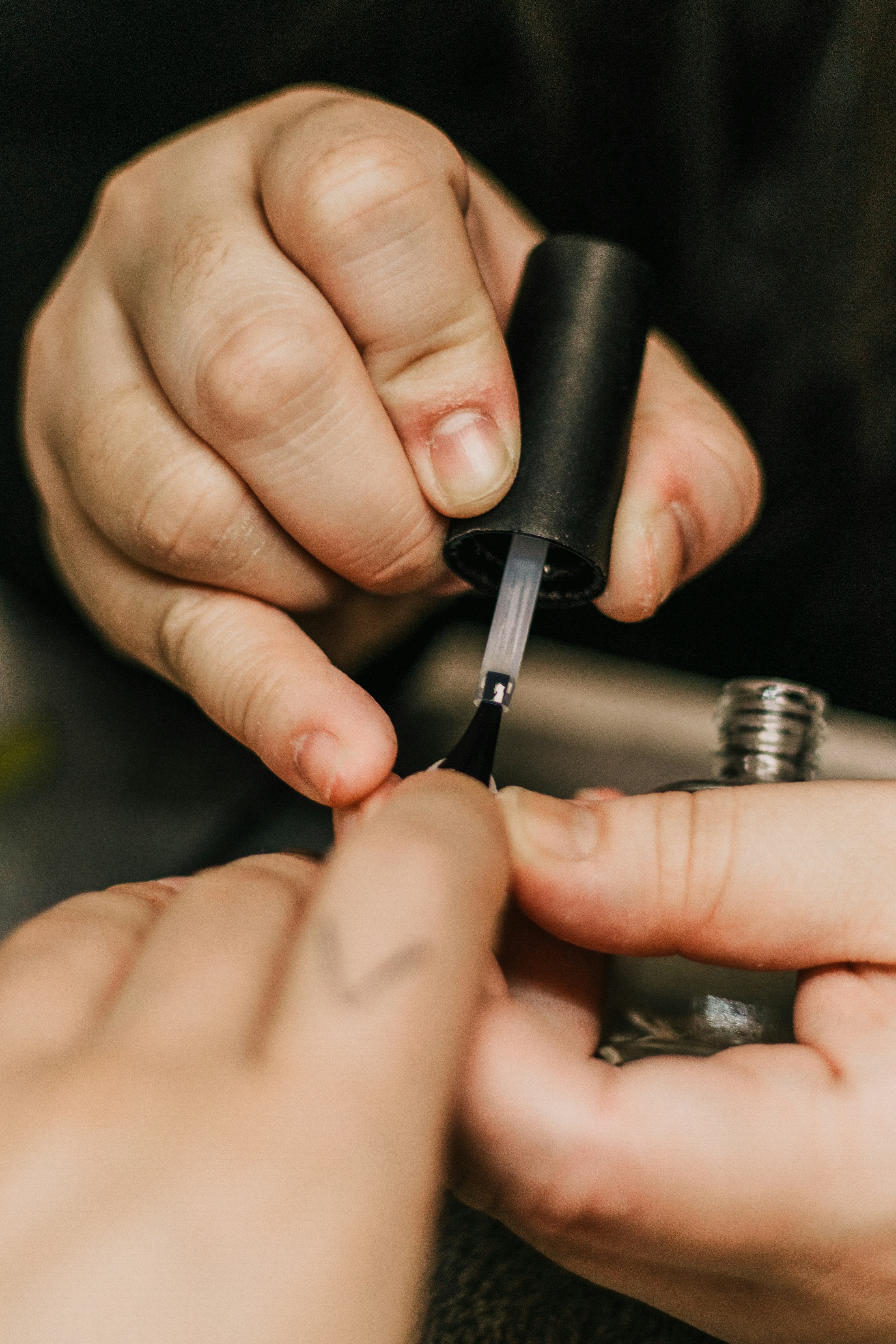 Close-up of a nail technician applying nail polish