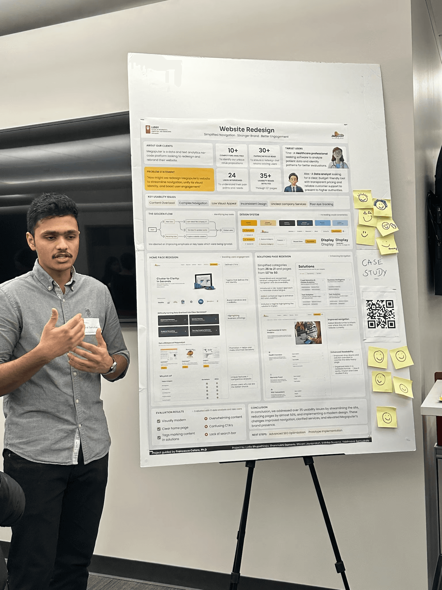 A man with a poster beside him, in a speaking pose