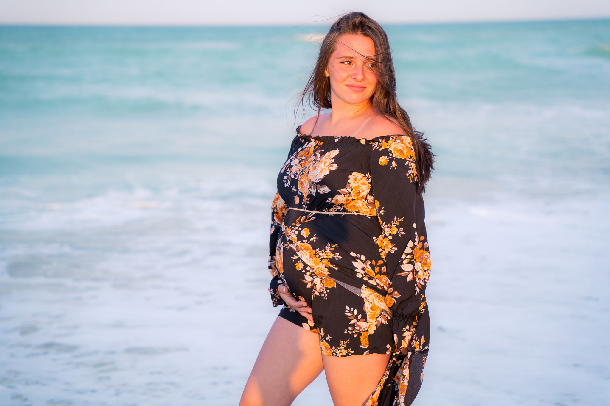 A pregnant woman standing in an ocean scene