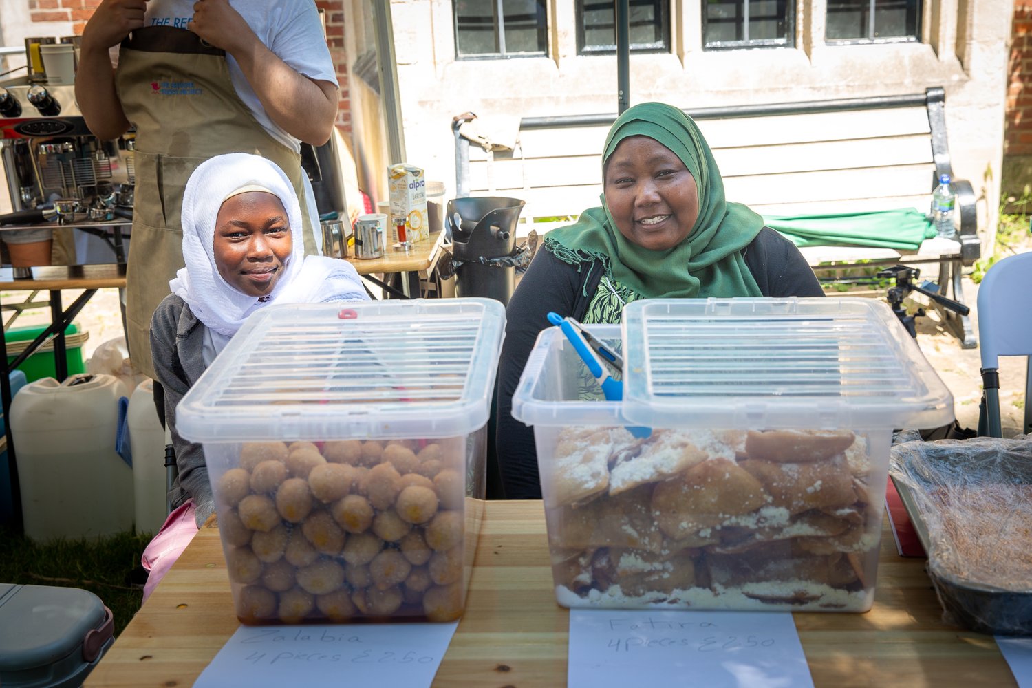 Two refugees with a food stall at Refugee Week