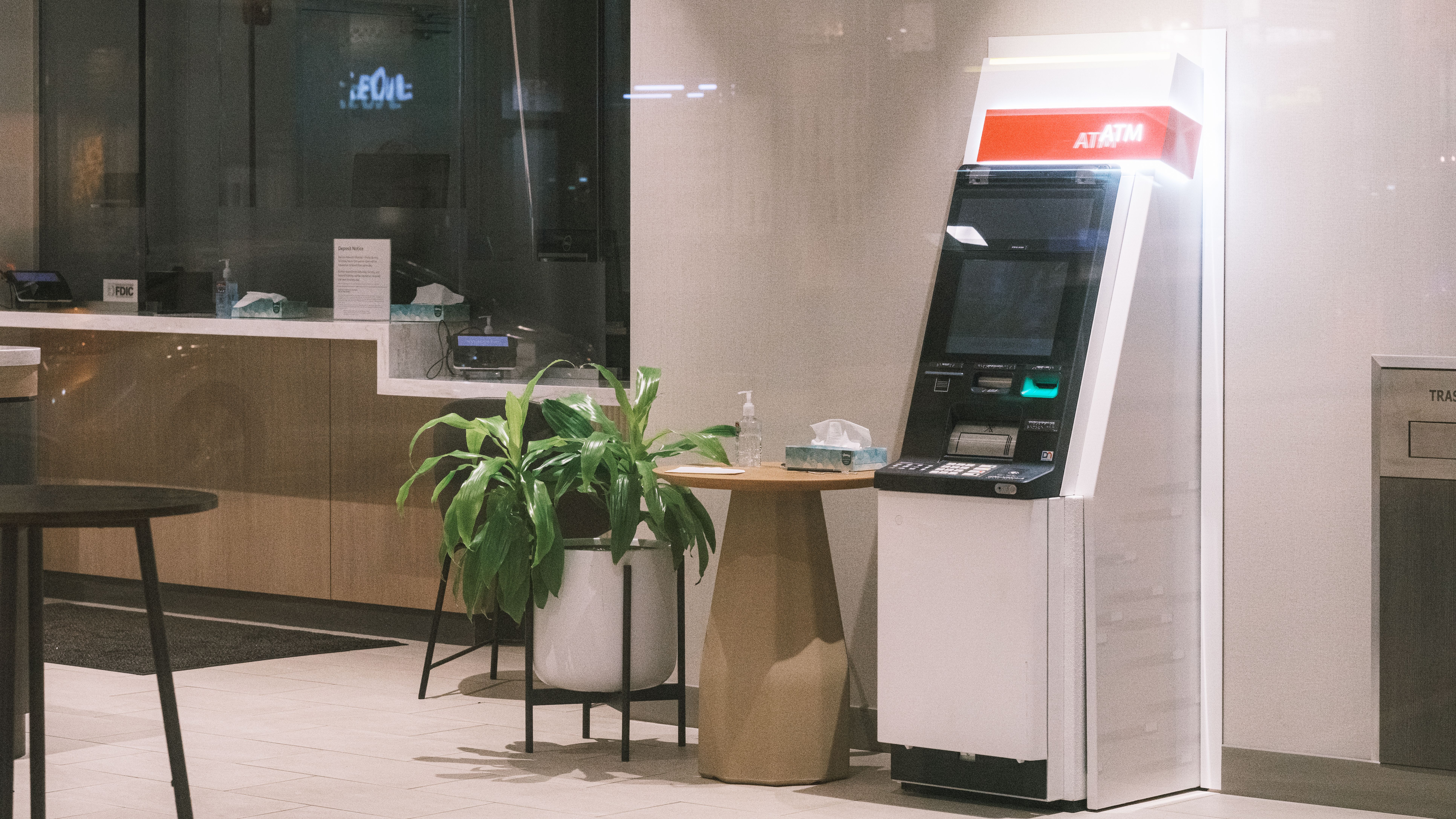 an-atm-machine-stands-in-a-modern-bank-lobby,-next-to-a-plant-and-table. - alec-adriano (pexels)