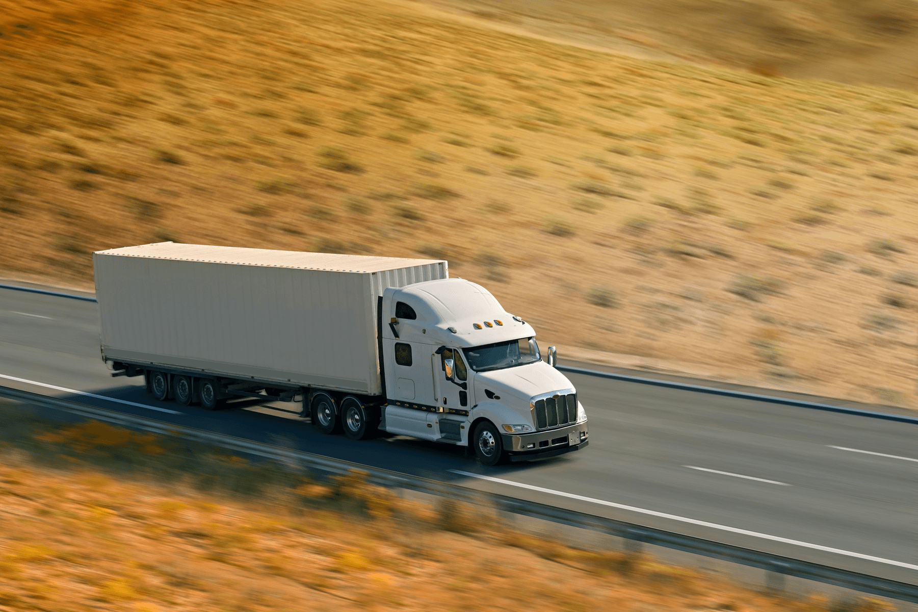 Long exposure photo capturing the speed and motion of a cargo truck on a highway, symbolizing the future of the trucking industry, with orange tumbleweed undergrowth and dynamic light traces representing efficiency and mobility in modern freight