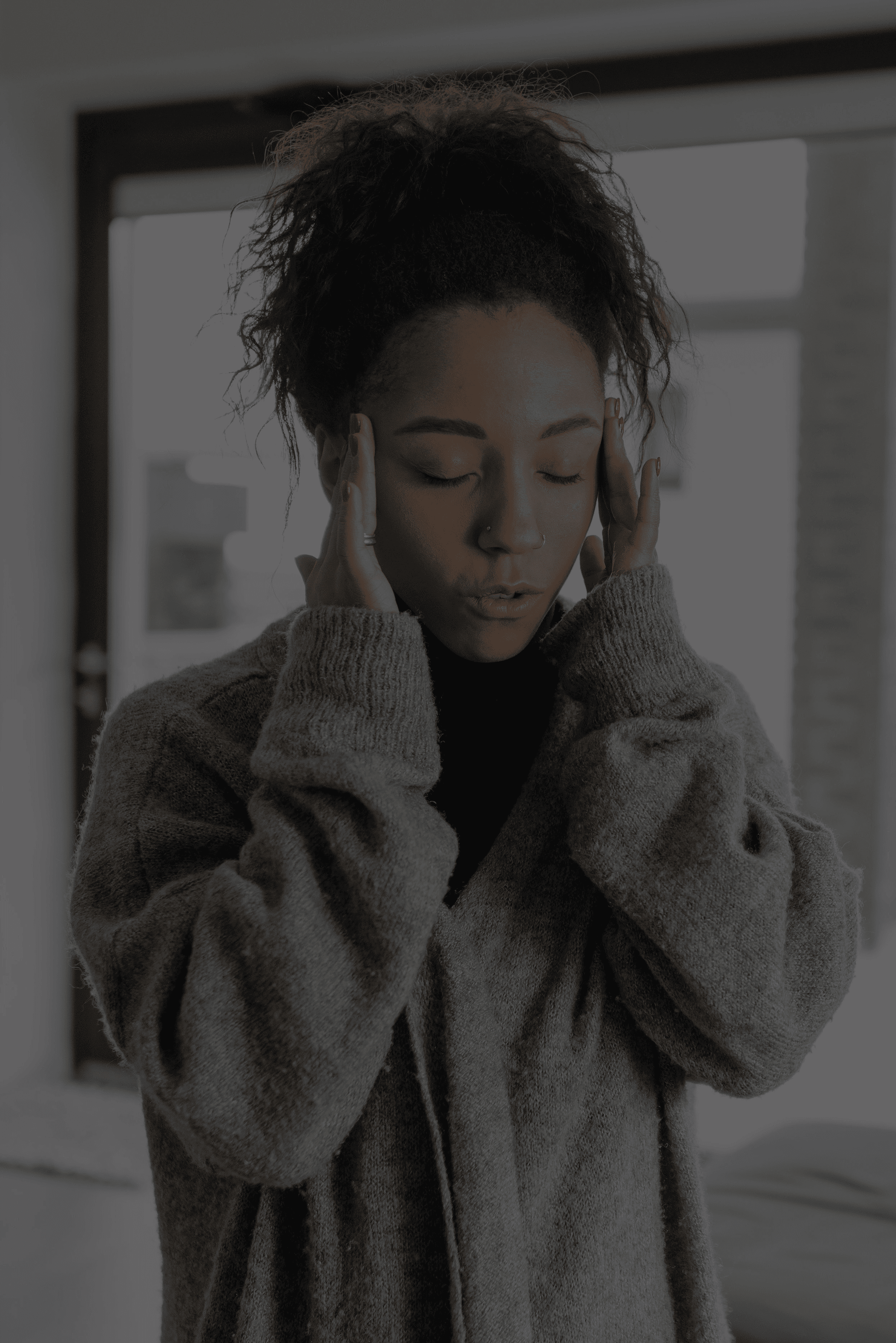 Woman with hands pressed to her temples representing the distress of intrusive thoughts and OCD anxiety