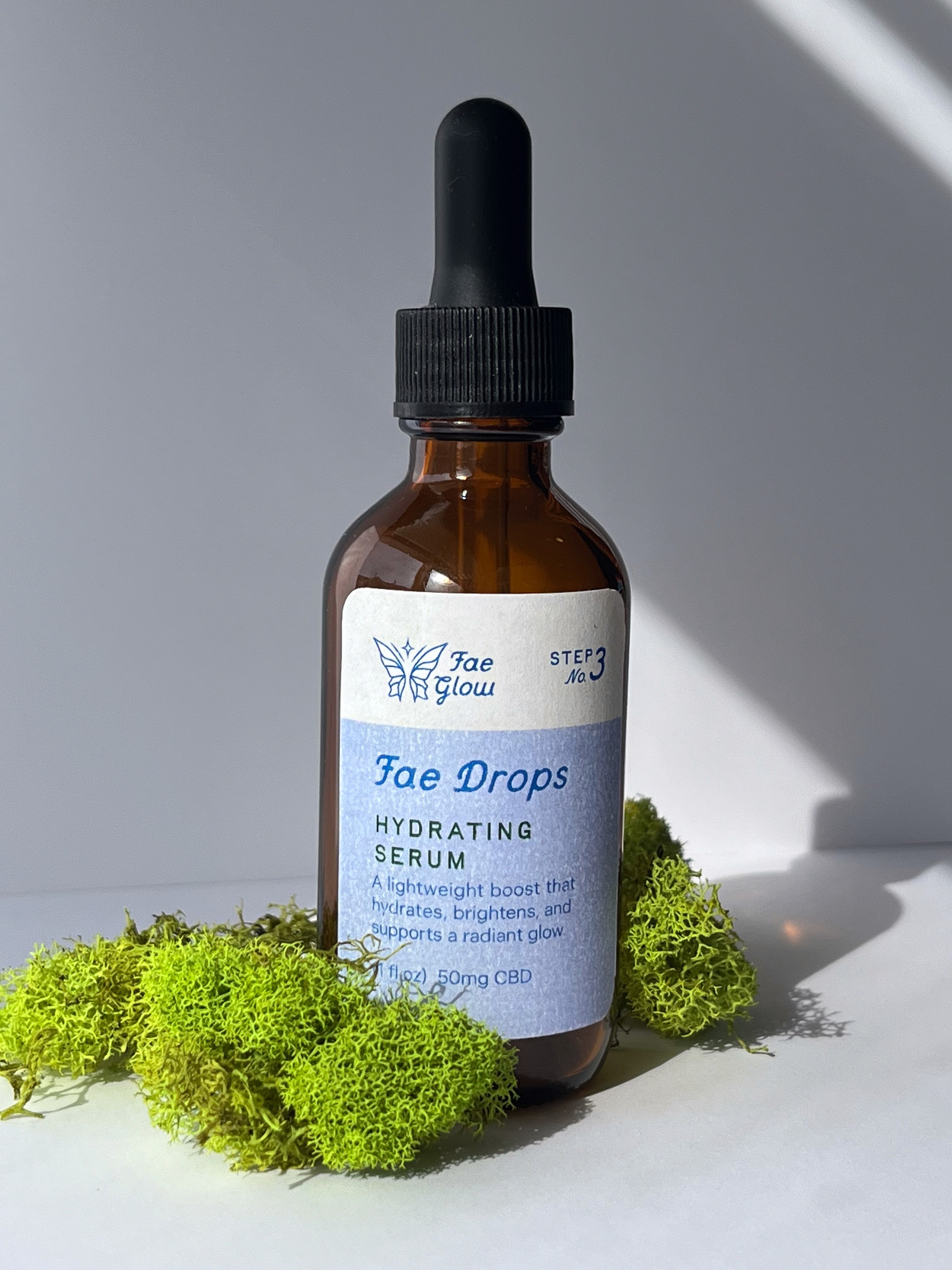 Brown glass dropper bottle with a blue label, surrounded by green grapes on a light gray background.