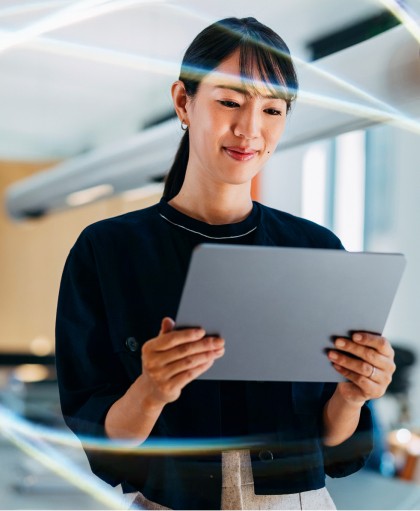 A smiling professional woman using a tablet in a modern office, showcasing automated time management for business and streamlined company productivity workflows.
