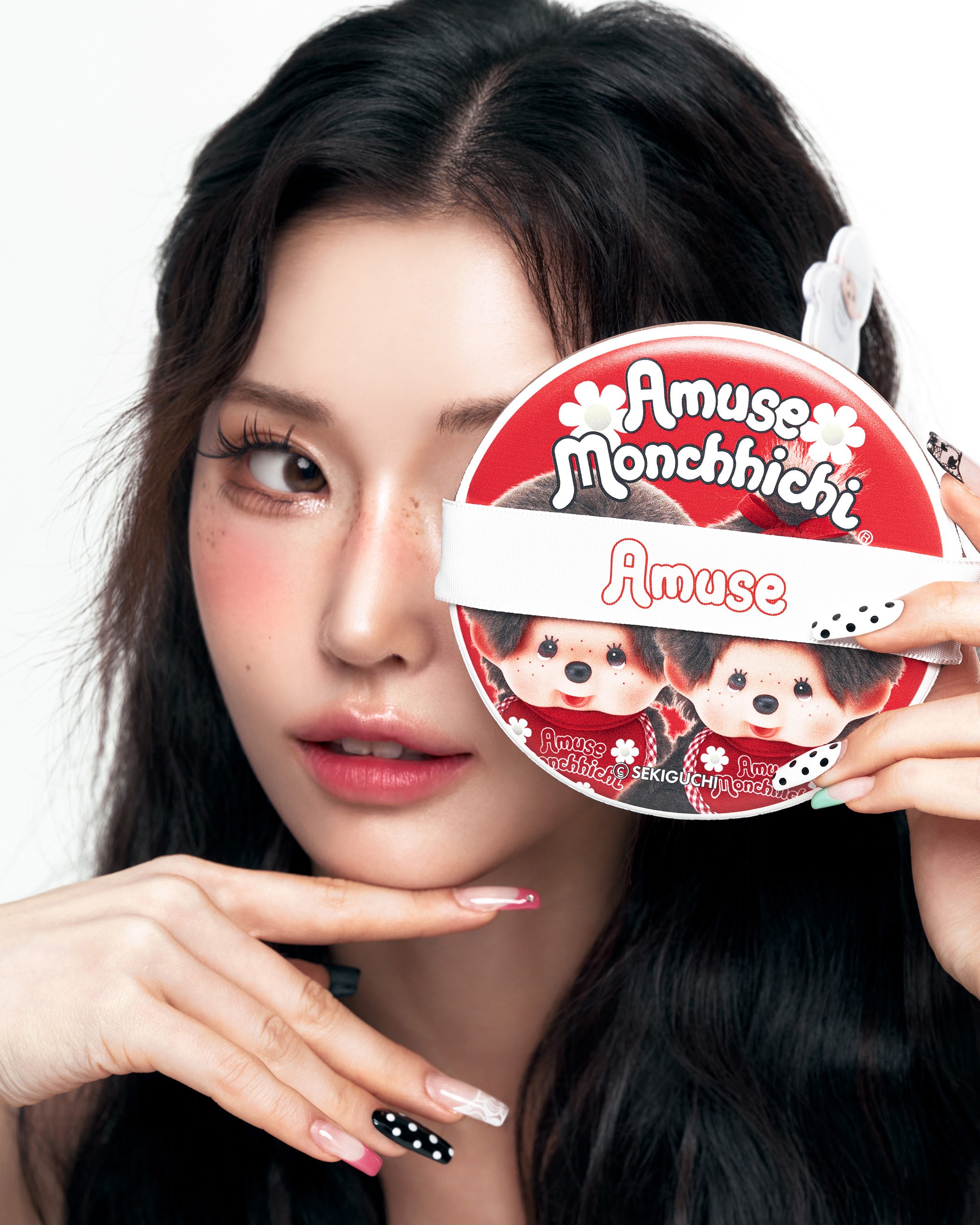 AMUSE X MONCHHICHI 원형 패키지를 얼굴 앞에 든 모델의 클로즈업