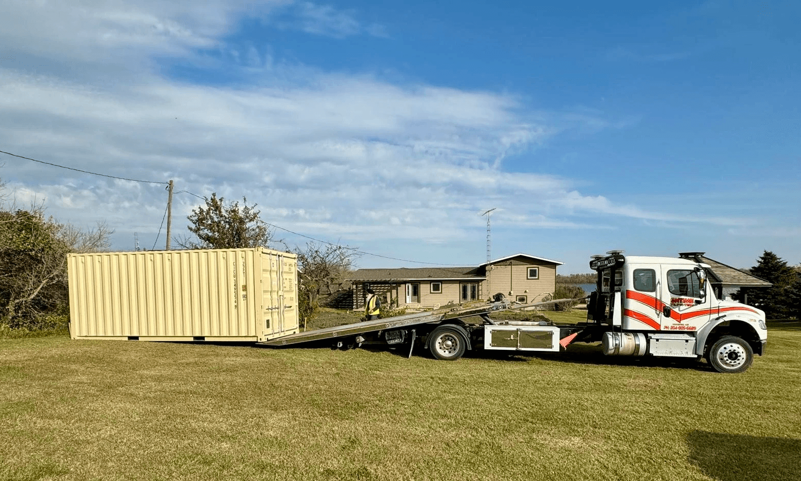 Container delivery driver lowering 20' double door unit using tilt bed mechanism