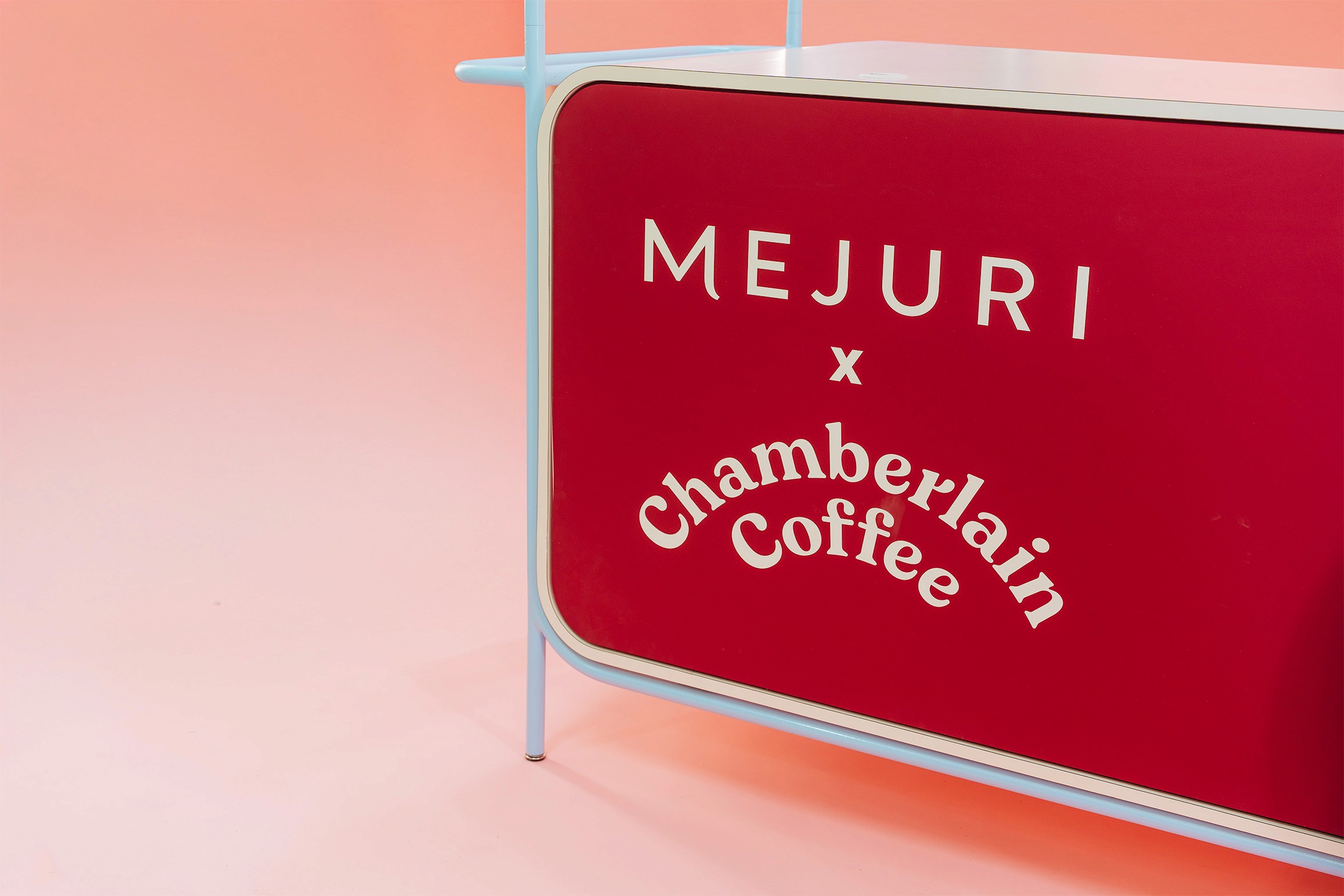 The front of a branded Mejuri coffe cart on a pink background