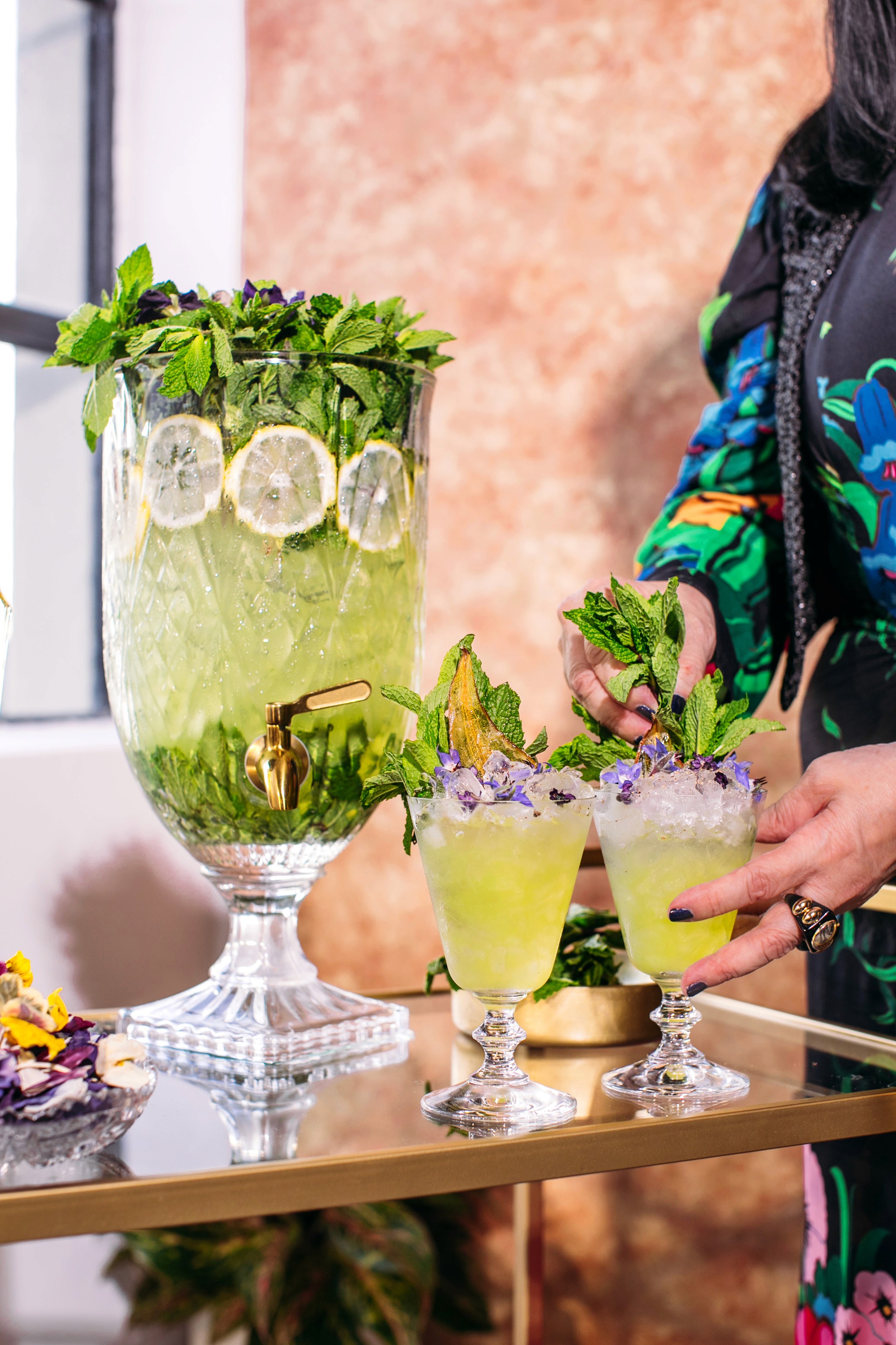 Anna Sui garnishing St-Germain cocktails beside the holiday punch bowl