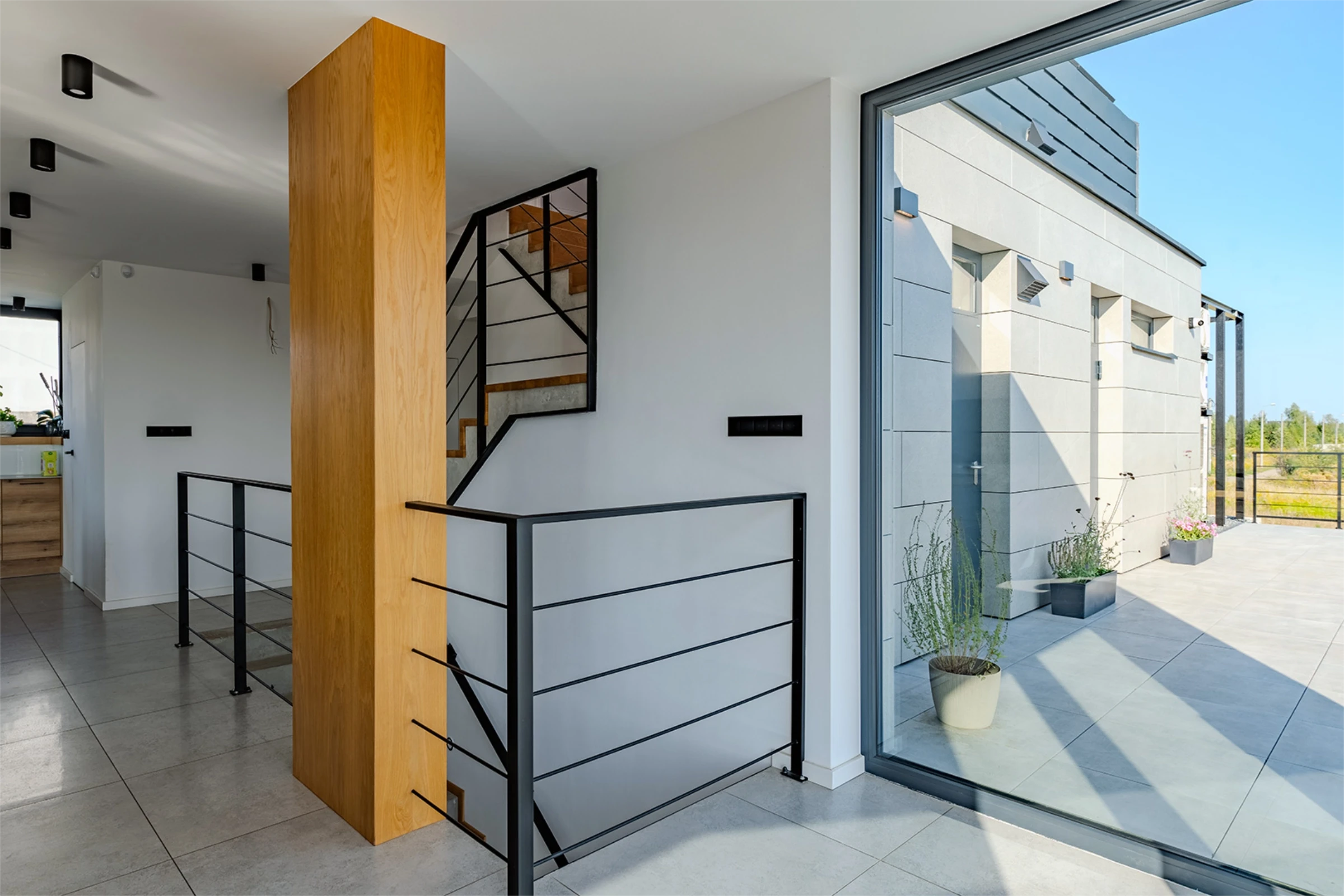 Wnętrze jasnego domu, klatka schodowa i przedpokój, pomalowane na biało