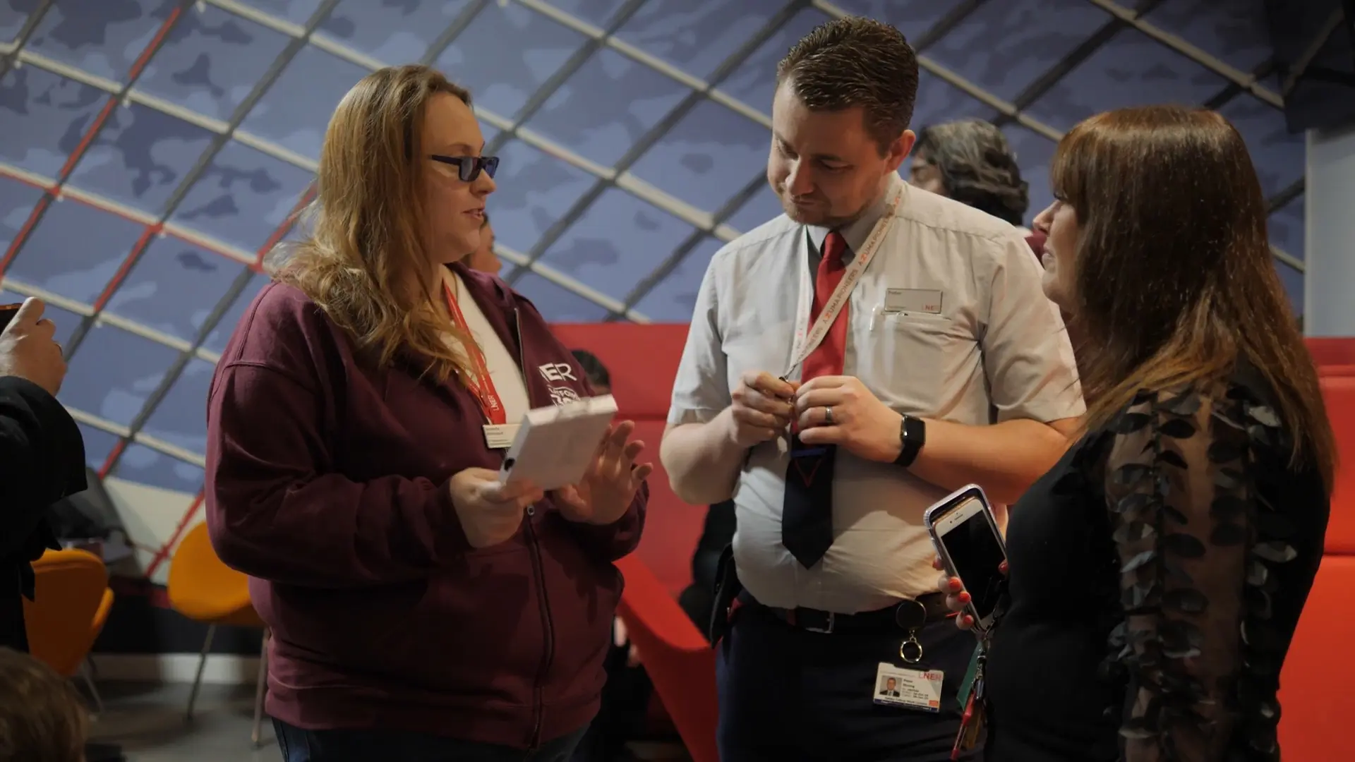 LNER colleagues discussing a mobile device during a Platform 365 training session.