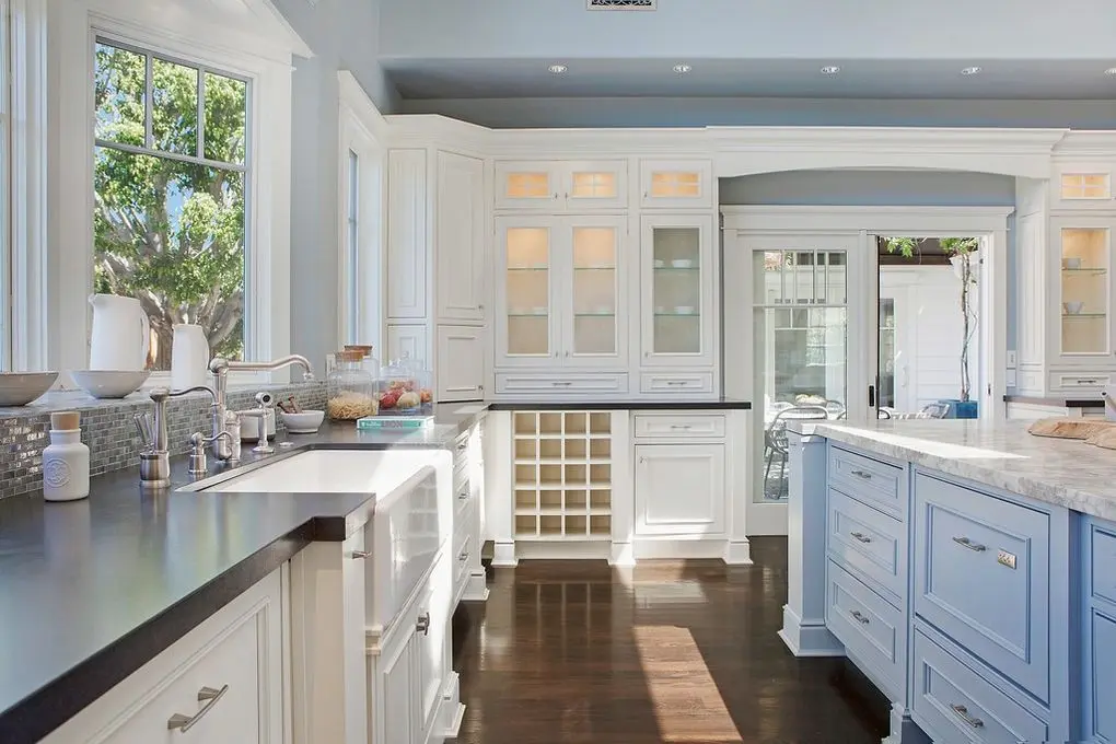 'Port Streets Remodel' showcases a kitchen with white and blue cabinets, marble countertops, and stainless steel appliances, framed by large windows and dark wood floors.