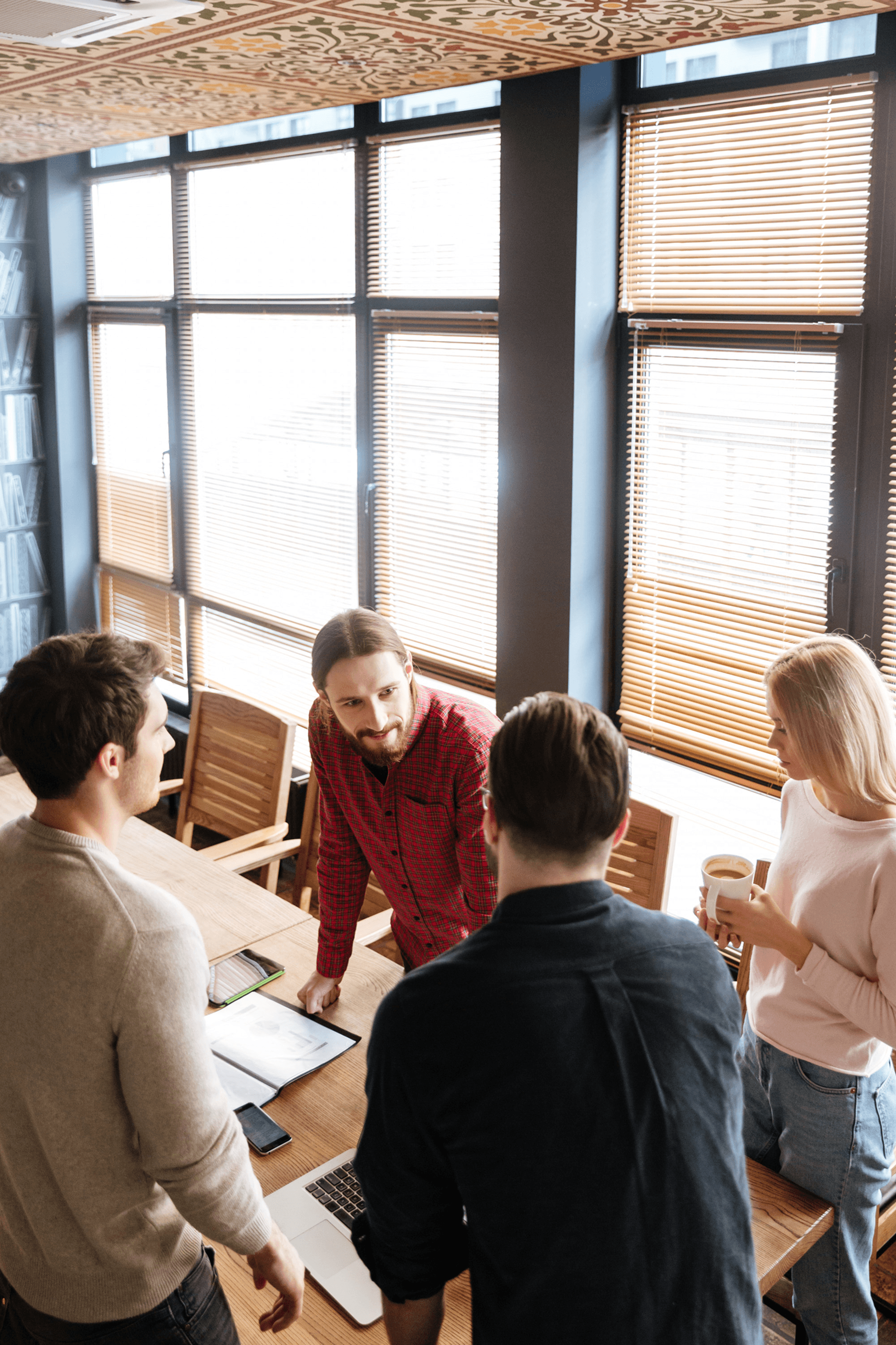 Professional men engaging in workplace collaboration and networking during an office coffee break.