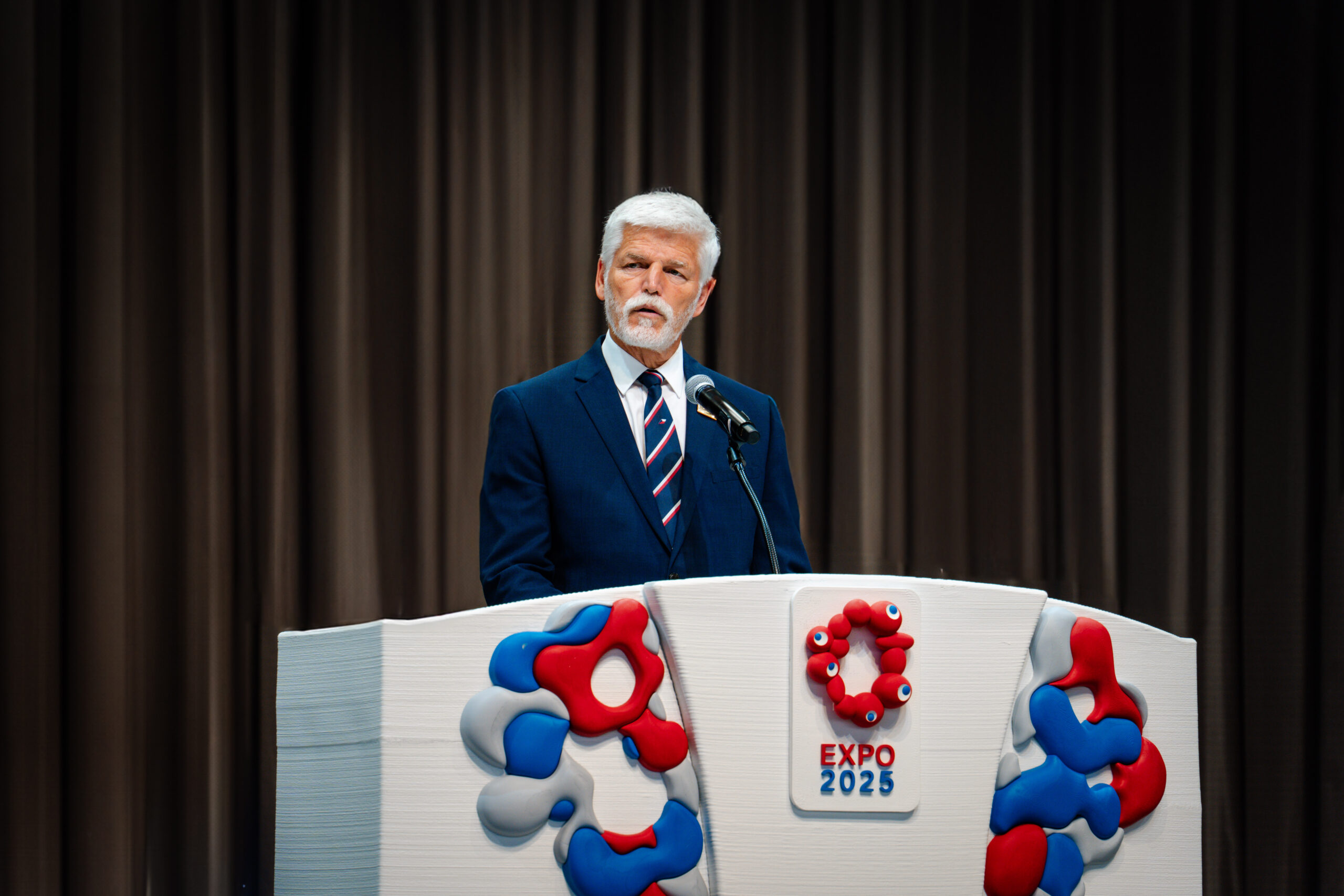 A man and woman walking together along a beautiful, well-maintained trail in a mountainous area.