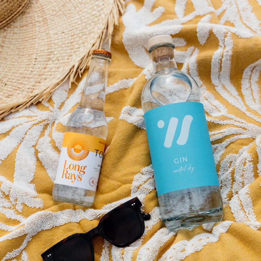 Two Tales Gin bottle on a beach towel