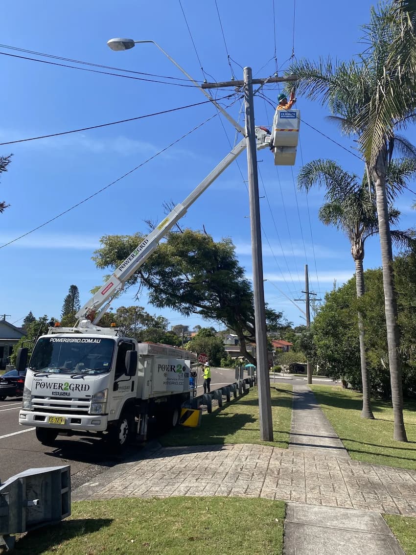 An image of the Power2grid technician working on a powerpole