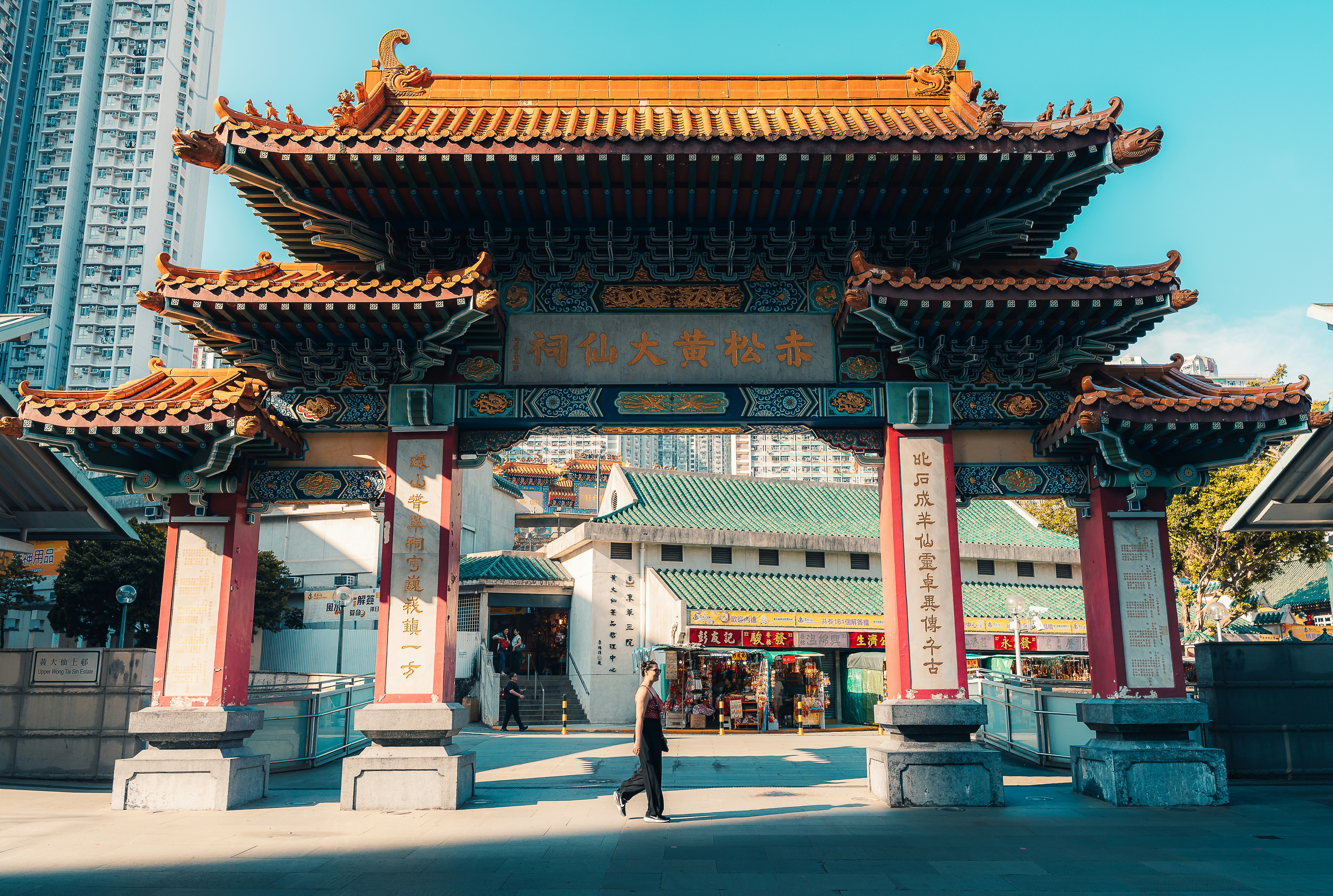 Ornate traditional chinese temple gate with modern buildings behind