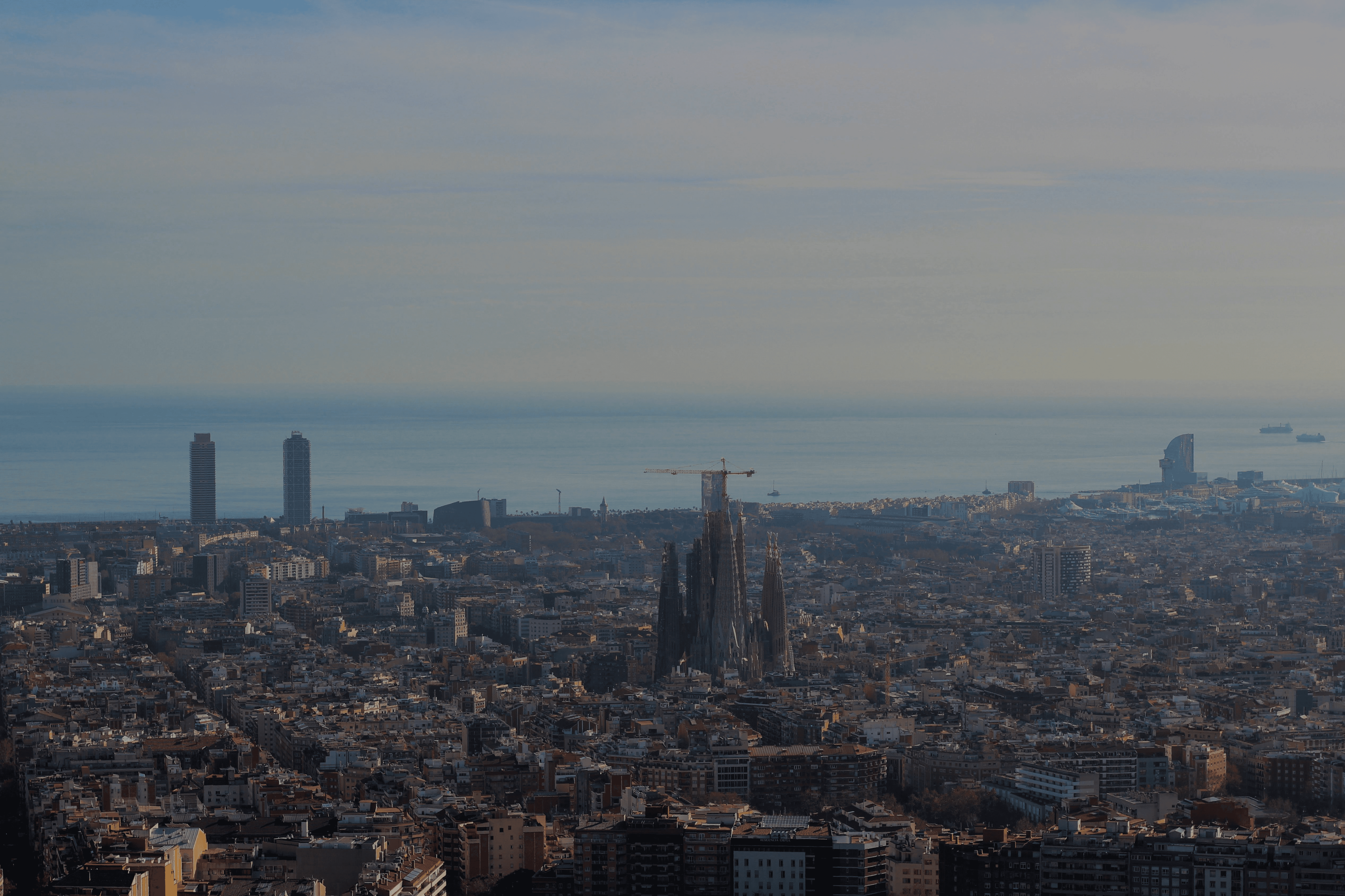 Skyline van Barcelona met uitzicht op de stad, Sagrada Familia, zee en bergen met zonsondergang.