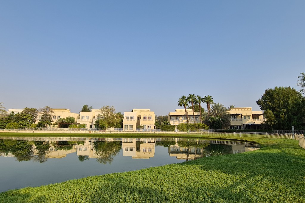 A panoramic view from Palm Island Resort, showcasing lush greenery and the skyline of Meadows 9, Dubai.