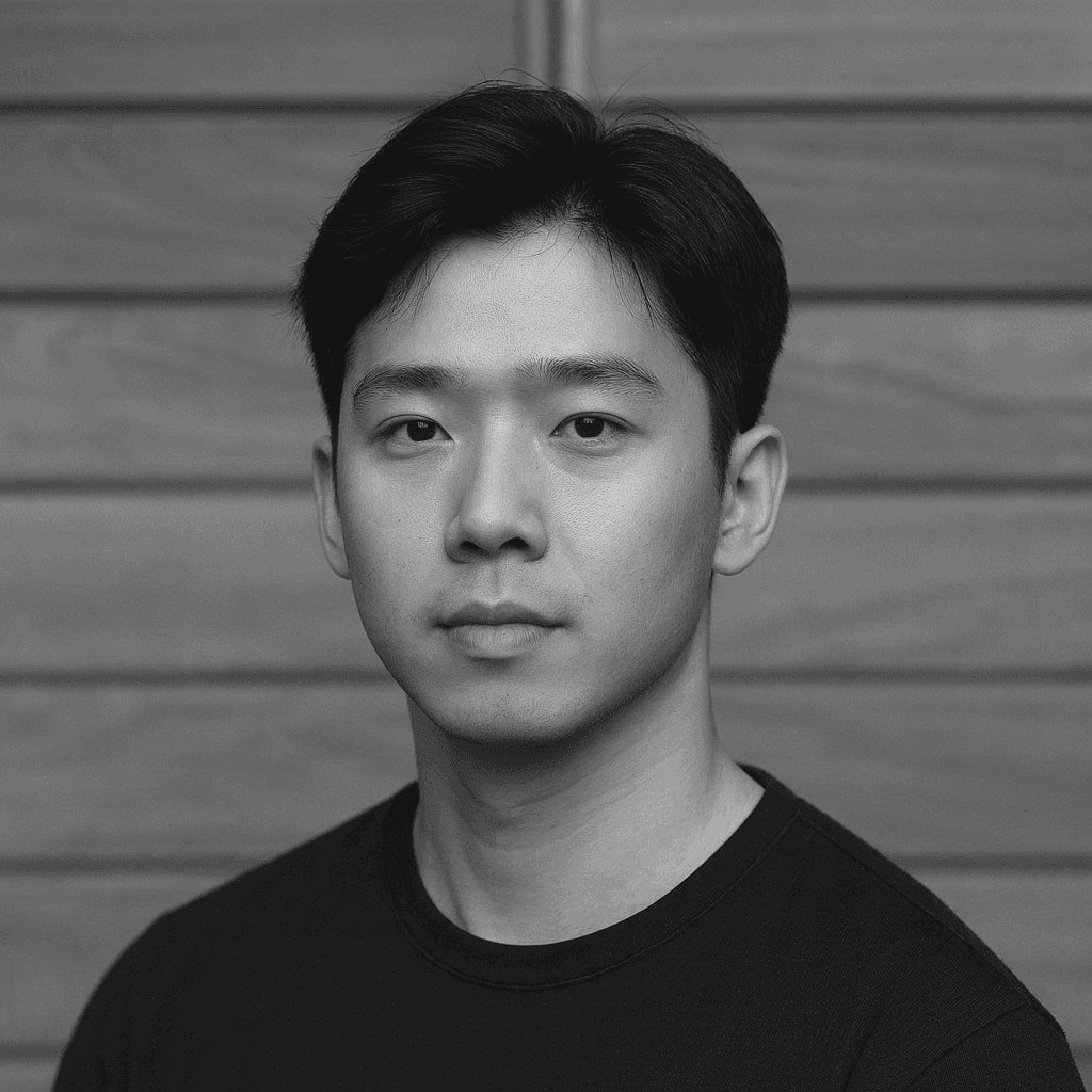 Professional headshot of a brunette woman in a white shirt, arms crossed, on a clean minimal background.