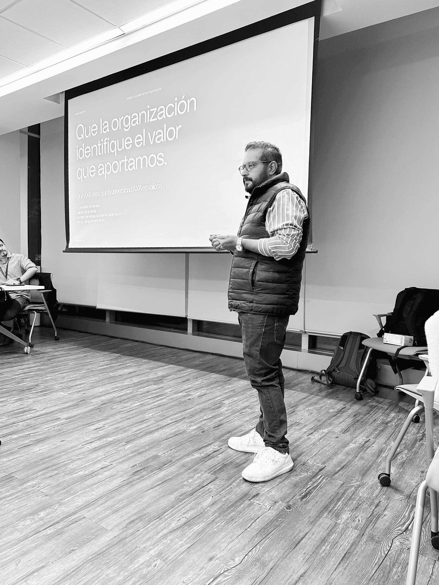 Alex Talavera de pie frente a un pizarron dando una charla