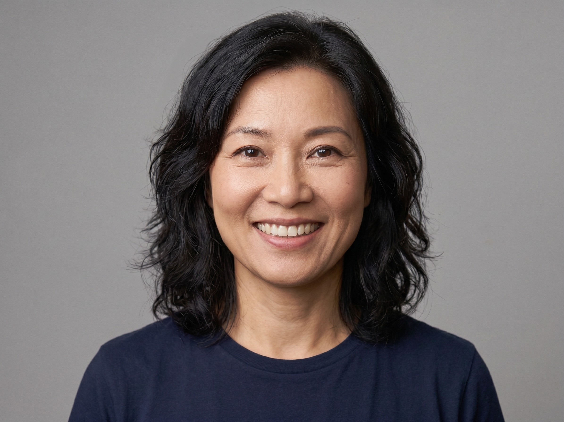 A person smiling and posing with a serious expression.