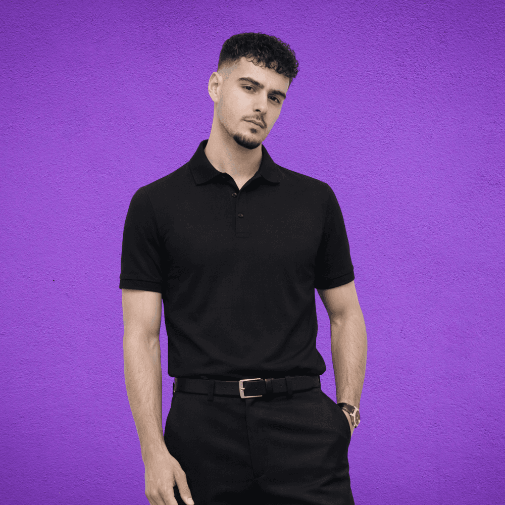 a man looking at the camera in a black polo and slacks
