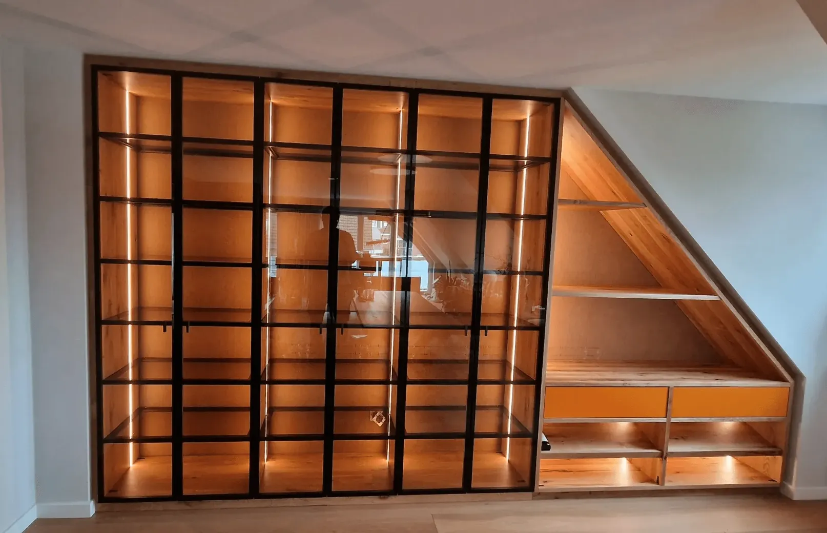 Maßgefertigtes Regal mit Glasfront unter Dachschräge