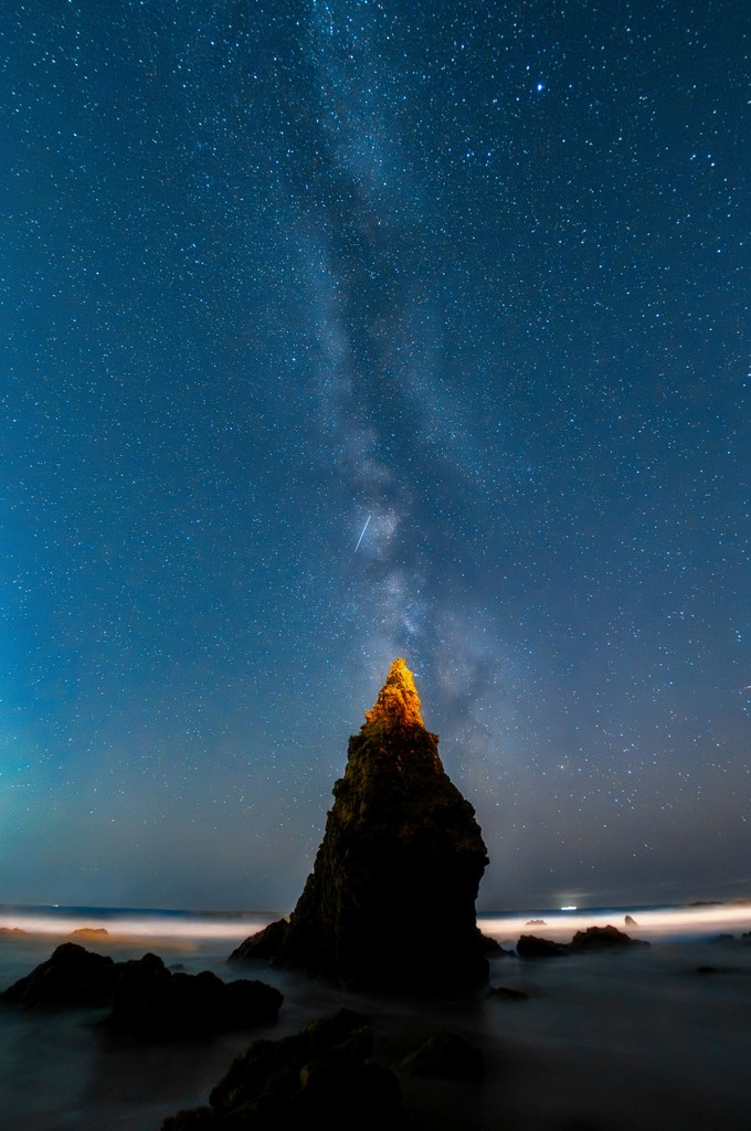 The night sky with stars above a rock formation