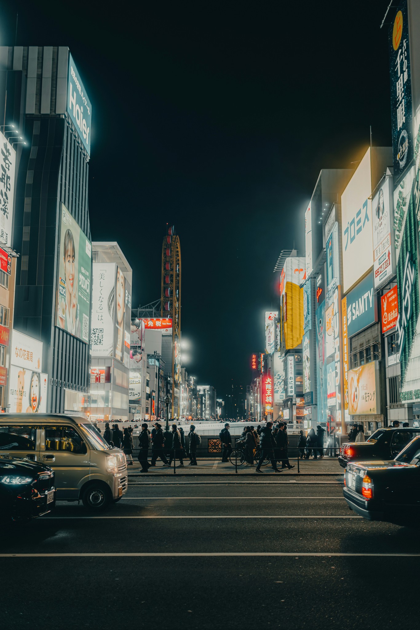 Busy city street at night with neon signs