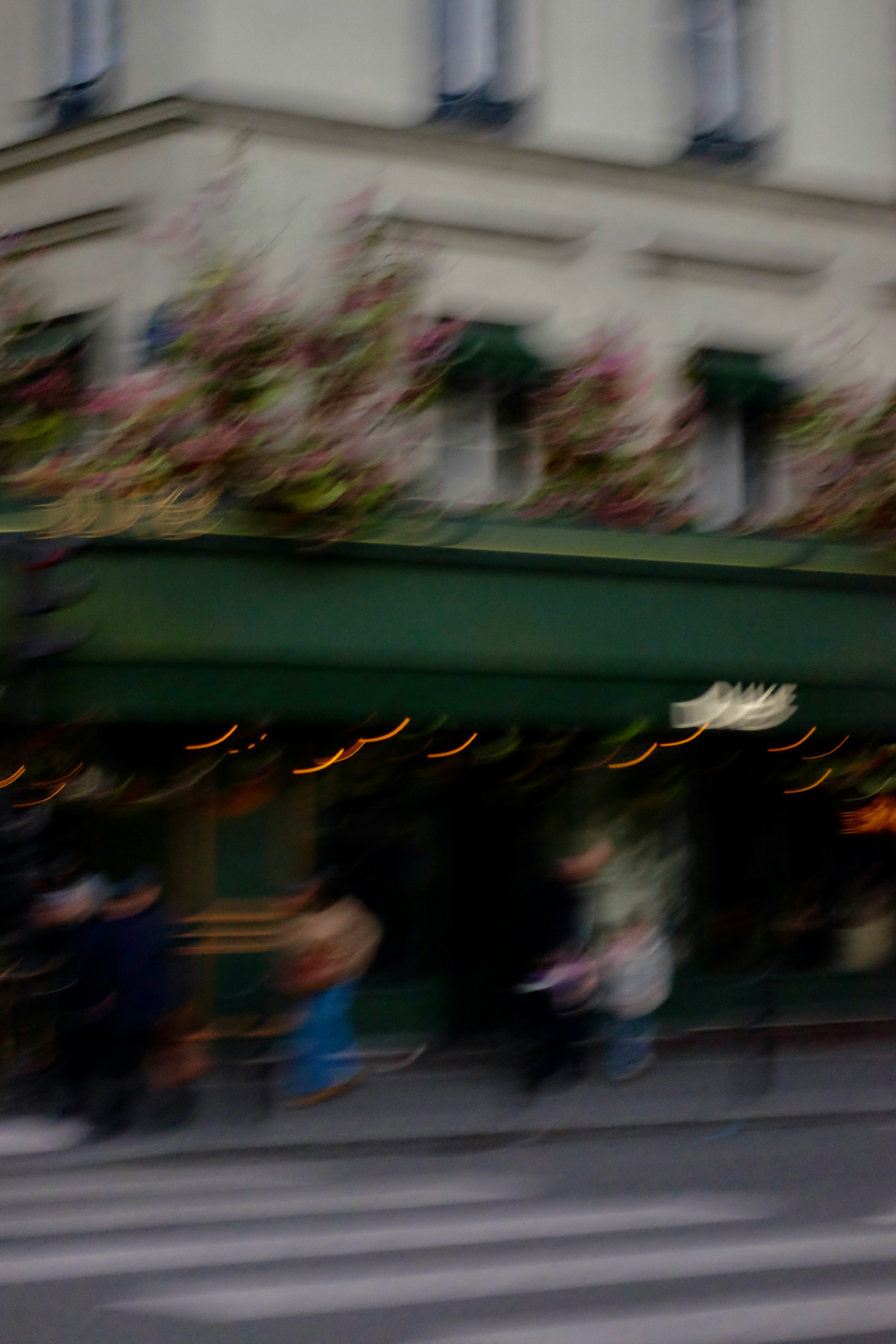 Blurred street view of a cafe with people.
