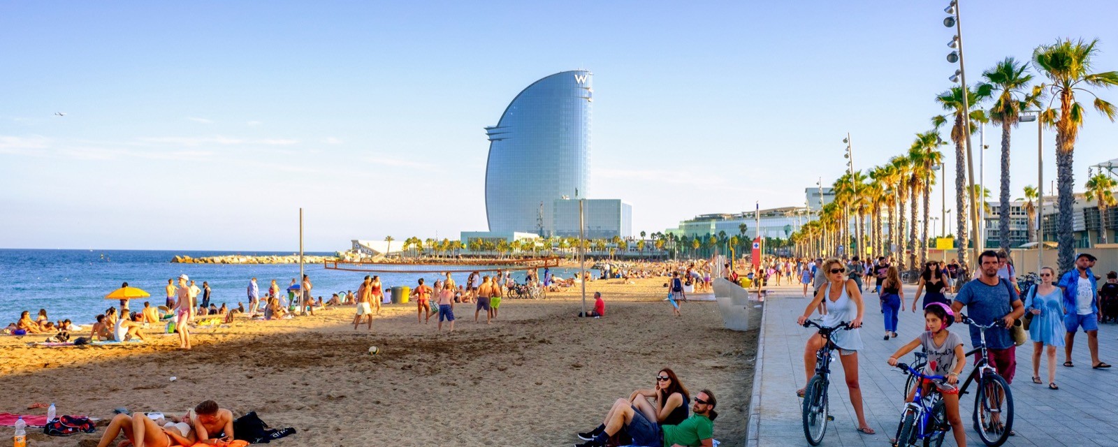 Families on a sunny Barcelona city beach in summer