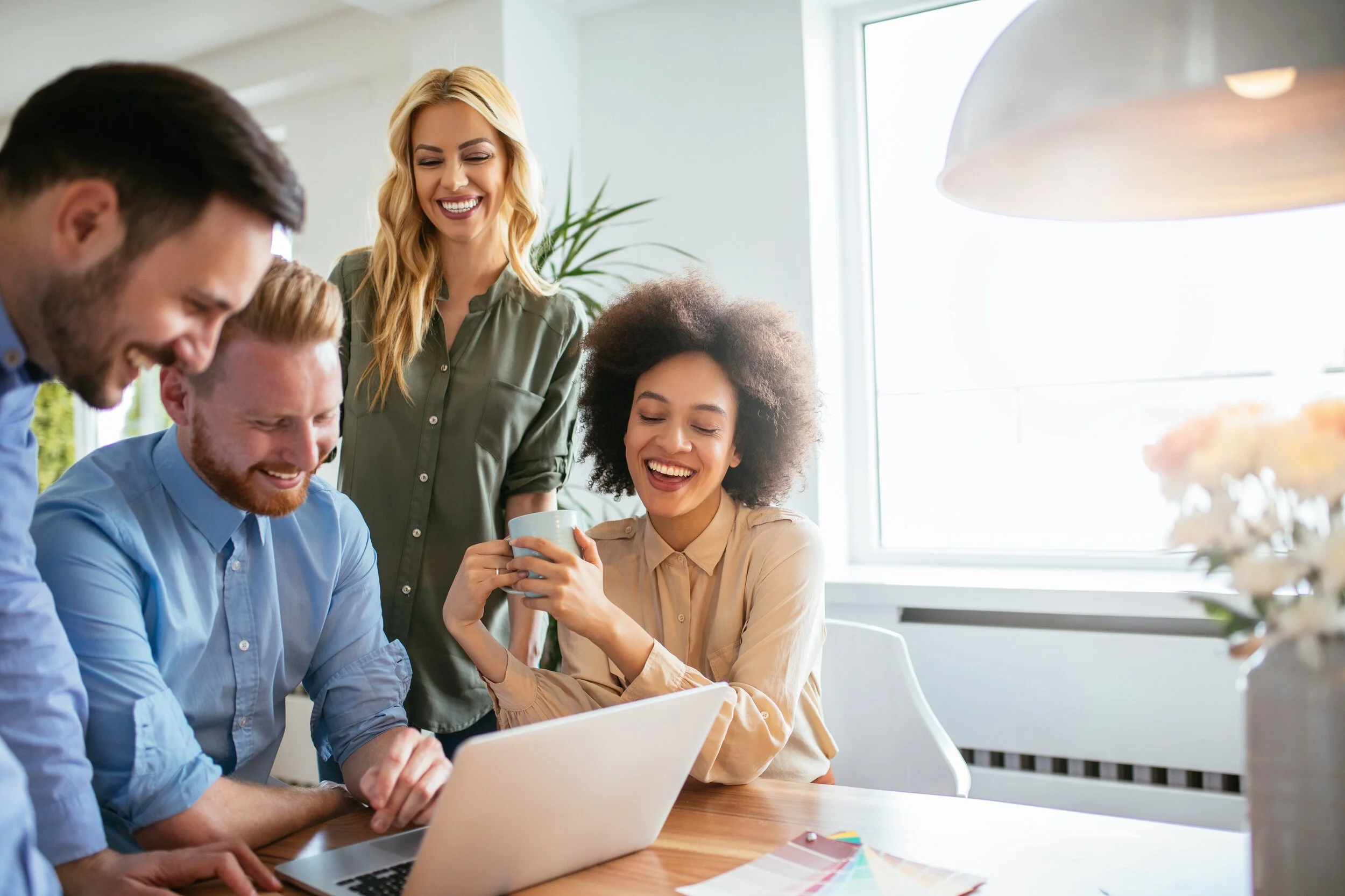 Employees crowded around a laptop