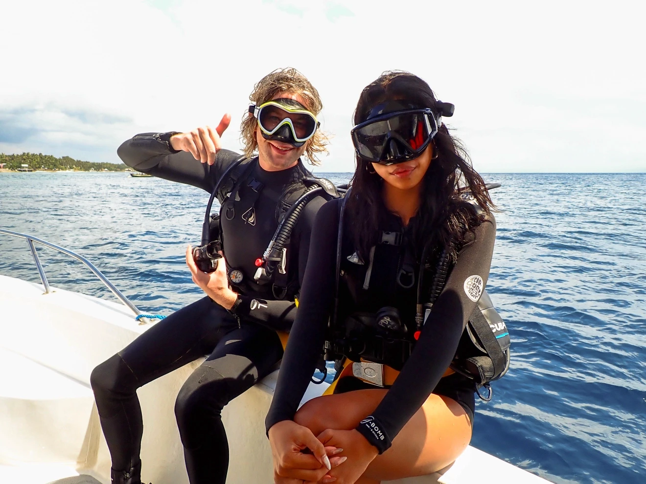 Person wearing a blue puffer jacket and red backpack standing in front of a light blue building on a city street.