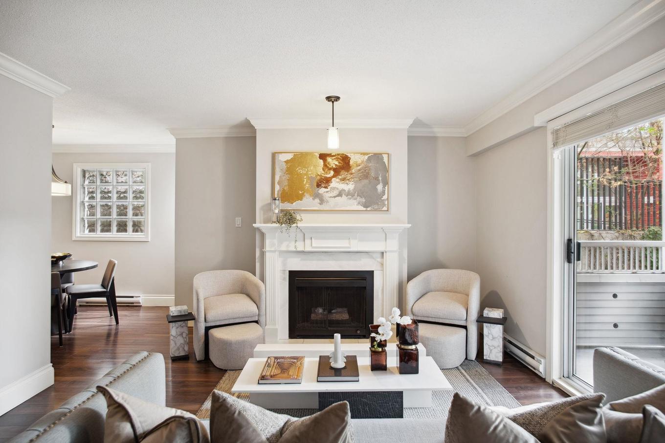Bright, modern living room featuring a cozy fireplace, artwork, and stylish seating.