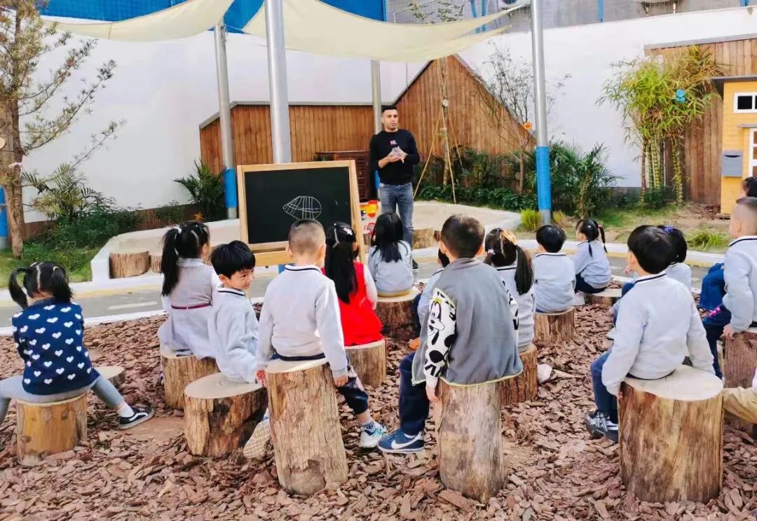 Modern minimalist home office with a built-in daybed, sleek desk, floating shelves, warm ambient lighting, and a large window with blinds.