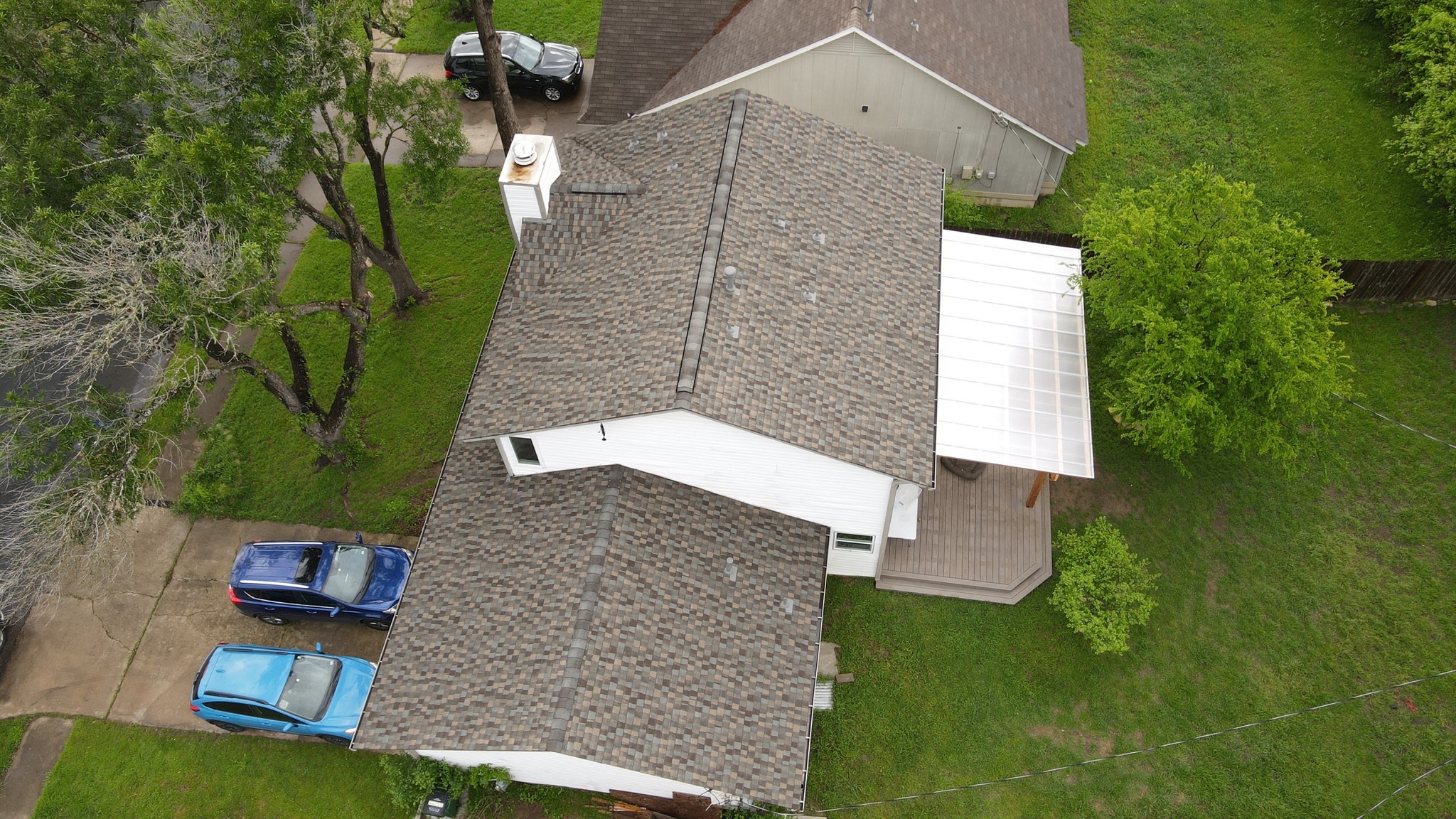 Beautiful fall-colored GAF HDZ architectural shingle roof, complemented by a polycarbonate porch roof, combining vibrant aesthetics with durable protection.