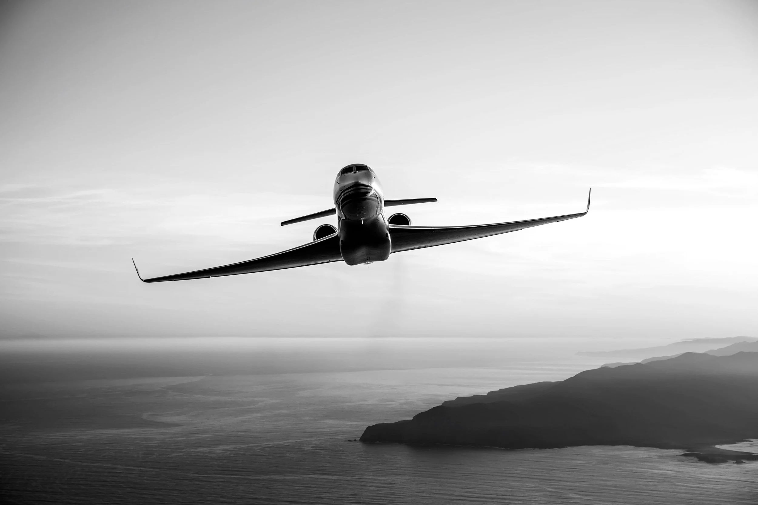 A private jet flying low over the water at high speed