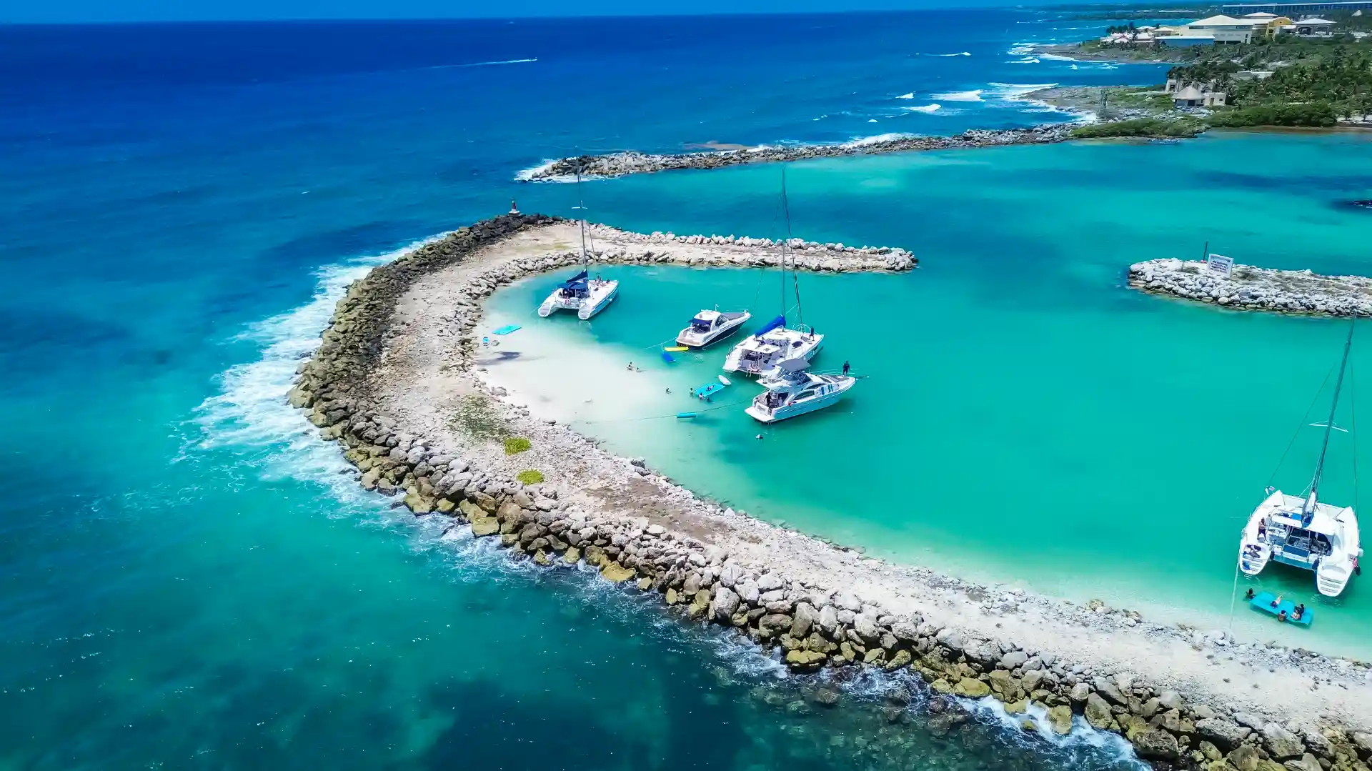 Aerial drone view of a tropical coastline with turquoise lagoon, sandy peninsula and clear shallow waters