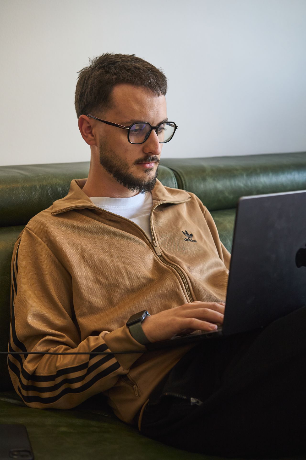 Person working on a laptop at a wooden table, coffee cup beside it