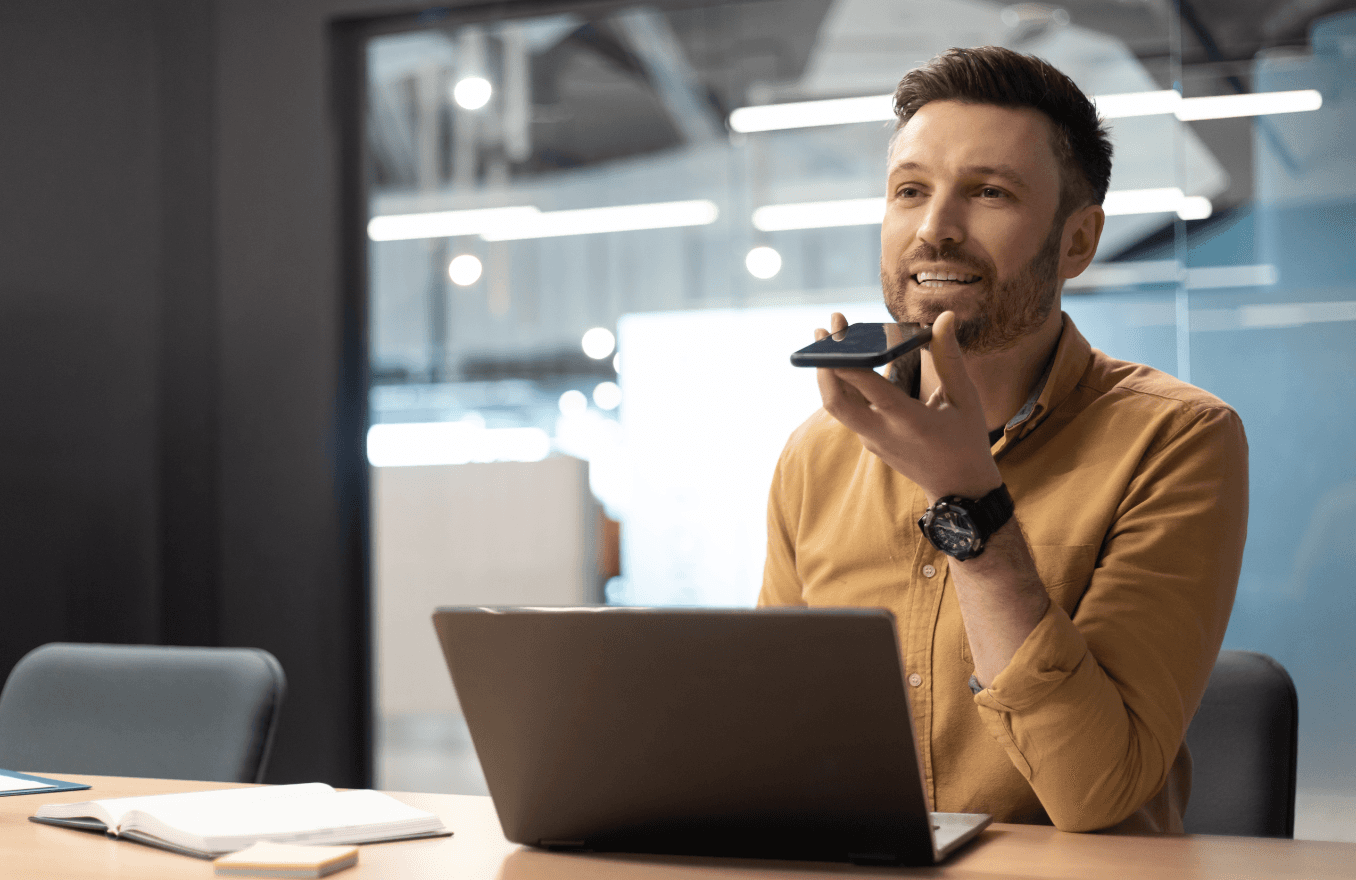 man wearing headphones while sitting on chair in front of MacBook