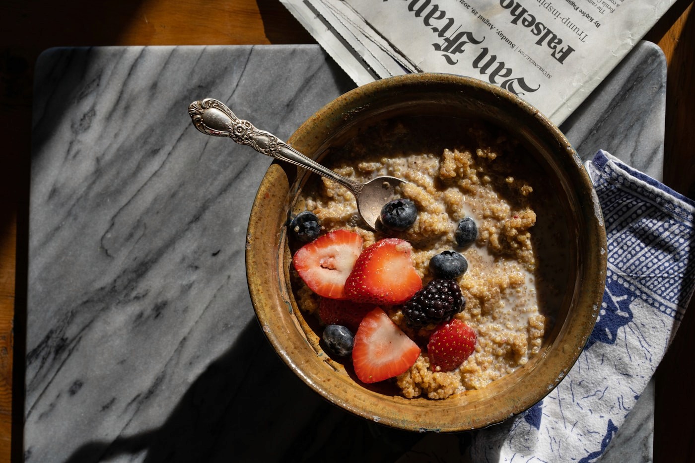 A carbohydrate-rich bowl of oatmeal topped with fresh fruit, a comfortable pre-run meal eaten a few hours before a long session.