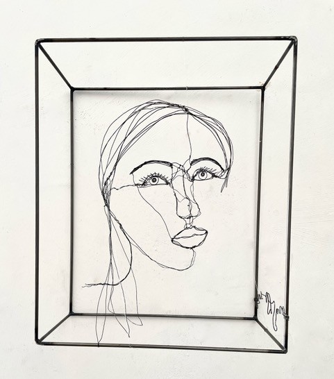Sculpture en fil de fer représentant le visage d'une femme dans un cadre en fil de fer, vue détaillée de face