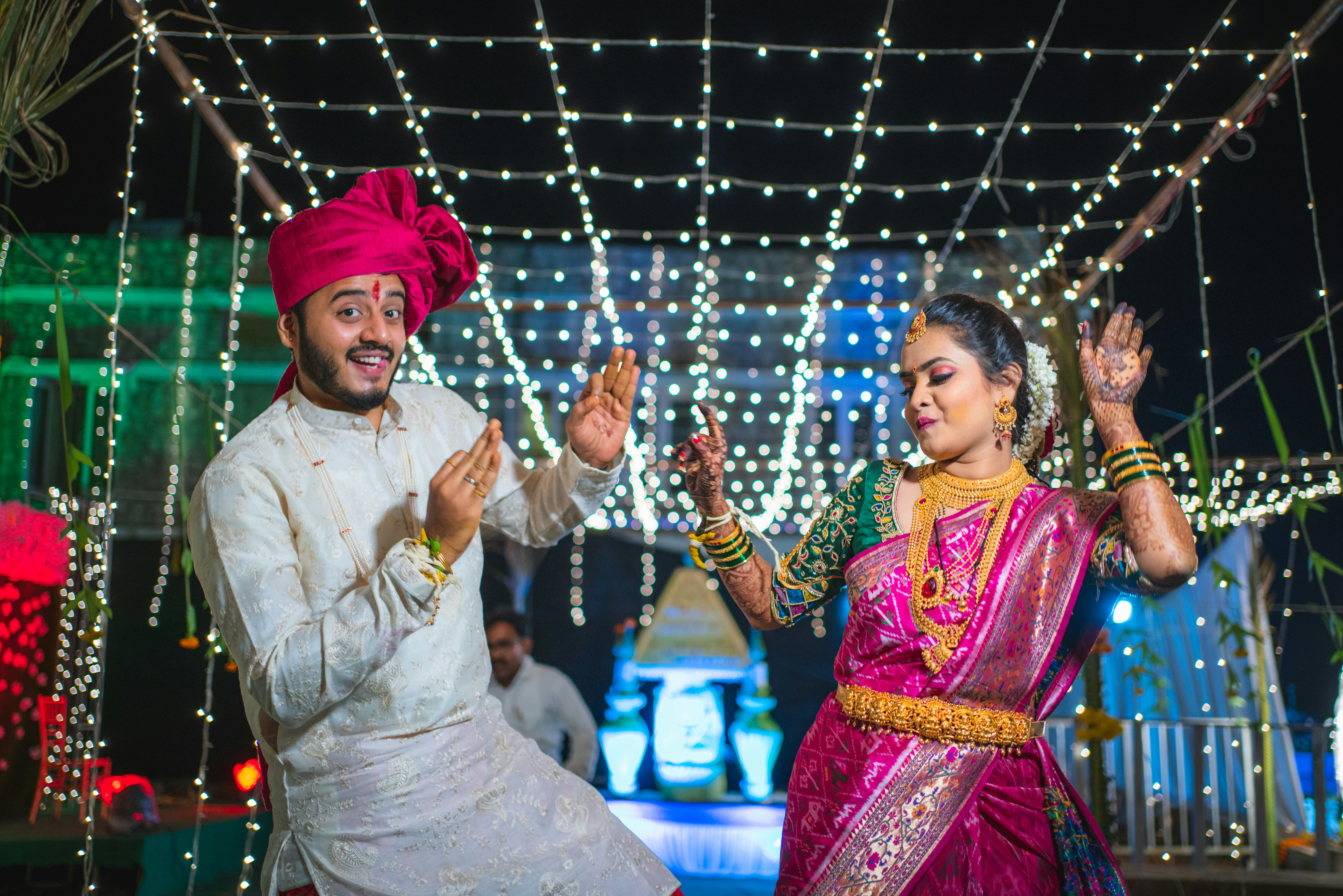 Couple dancing under warm fairy lights at an evening sangeet